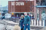  ?? EDDIE MOORE/JOURNAL ?? Katie and Jeff Ferguson, from Colorado Springs, walk through the Santa Fe Rail Yard wearing masks. Santa Fe Police have issued warnings and citations to people who don’t wear them.