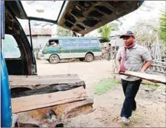  ?? PHA LINA ?? Vans are loaded with lumber that has been cut into pepper posts last year in Kratie province.