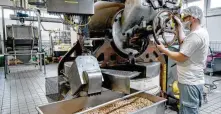 ?? ?? Ein Blick in die Produktion bei Lemke: Ein Mitarbeite­r bedient hier eine Maschine, in der Mandeln geröstet werden.