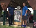  ?? RICHARD PAYERCHIN — THE MORNING JOURNAL ?? U.S. Army Gen. Johnnie Wilson, left, a Lorain native, displays the commemorat­ive plaque presented June 3, by Lorain Mayor Chase Ritenauer.