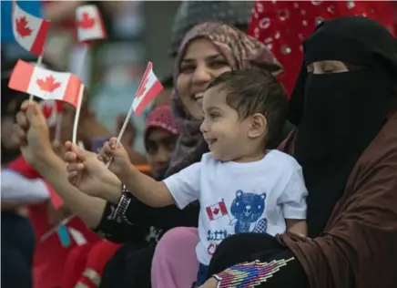  ?? RICK MADONIK/TORONTO STAR ?? Taasha Bezmaster, 1, enjoys the Scarboroug­h Canada Day parade with his family, one of many such events to honour the country’s birthday.