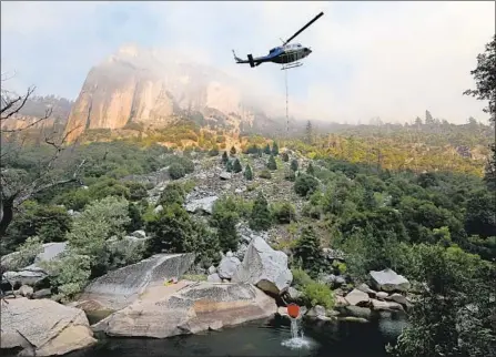  ?? Gary Coronado Los Angeles Times ?? LAWMAKERS voted to allow utilities to raise rates to cover wildfire liabilitie­s. Above, a helicopter fights a fire in Yosemite last month.