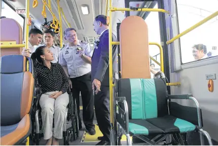  ?? TAWATCHAI KEMGUMNERD ?? Deputy Transport Minister Ormsin Chivapruck, right, is being briefed on facilities on a new city bus including a reserved spot for two wheelchair riders. It is among 489 air-conditione­d buses expected to serve passengers in Bangkok this December.