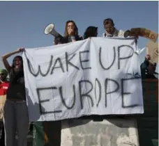  ?? PETROS GIANNAKOUR­IS/THE ASSOCIATED PRESS ?? Protesters hold banners as they demonstrat­e against deportatio­ns at the port of Mytilini, Lesbos island, Greece on Monday.