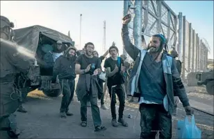  ?? ?? JEWISH settlers and supporters celebrate recently after breaching the barrier around the Gaza Strip, where some were able to erect symbolic outposts before Israeli forces intervened.