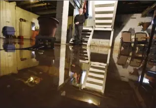  ?? PHOTOS BY JOHN RENNISON, THE HAMILTON SPECTATOR ?? Margaret Elliott stands on bottom step to her basement where water is bubbling up through cracks in the floor.