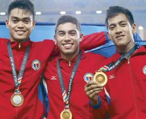  ?? JUN MENDOZA ?? Anthony Beram (above) hoists the Philippine flag as he makes the ceremonial run after ruling 200m dash and (left photo) with triple jump silver medalist Mark Diones (left) and decathlon winner Aries Toledo.