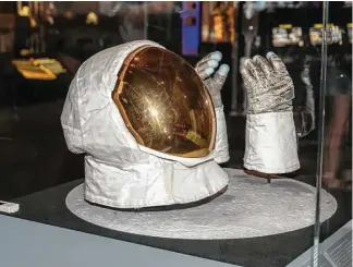  ?? Leslie Plaza Johnson ?? Lunar module pilot Buzz Aldrin’s helmet and gloves are on display at the Apollo 11 exhibit at Space Center Houston. Apollo 11’s Neil Armstrong was the first man to walk on the moon.