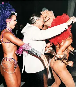 ??  ?? 1 Um dos convidados da festa que George Scheder organizou para a mulher Daphne com as dançarinas brasileira­s