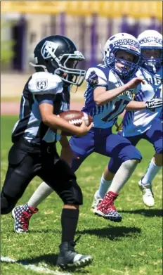  ??  ?? El Centro Trojans’ Jesus Cesena runs the ball during a home American Youth Football game against the Lake Havasu Chiefs on Saturday afternoon in El Centro.