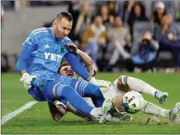  ?? PHOTO BY RAUL ROMERO JR. ?? Los Angeles FC forward Danny Musovski, right, collides with Austin FC goalkeeper Brad Stuver during the first half of an MLS match at Banc of California Stadium.