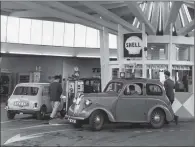  ?? PICTURES: FOX PHOTOS/ TOPICAL PRESS AGENCY/ GEORGE FRESTON / EVENING STANDARD/ GETTY IMAGES. ?? ON FULL BEAM: From top, a woman serving petrol from a home- made pump in the shape of a lighthouse in Glamorgan in 1939; Don Valley MP Tom Williams fills up the first car with petrol from British coal at a service station in London in 1935; a cashier checks the amount of petrol and resets the pumps by remote control at London’s first self- service filling station, in Southgate; Turnbull’s self- fill station in Plymouth.