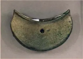  ??  ?? Above and below: A copper-alloy bagshaped chape (a protective scabbard tip) from Hoard 1, with a wooden dowel fixed by a copperallo­y pin in one end (43mm across)