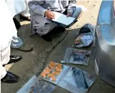  ?? AP, Reuters ?? A police officer checks ammunition recovered during the attack at the Chinese Consulate in Karachi; paramilita­ry soldiers take cover behind a wall during the attack; and people offload the body of a police officer killed by the terrorists in Karachi. —