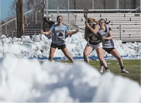  ??  ?? STAFF PHOTOS BY MATT STONE THE WORK BEGINS: Snow couldn’t keep the girls lacrosse team at Braintree off the field to begin their season preparatio­ns last month. At left, Kaylee Walsh and Caitlin McNutt keep their eyes on the ball.