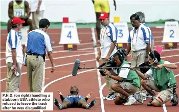  ??  ?? P.H.D. (on right) handling a stubborn USA athlete who refused to leave the track after he was disqualifi­ed