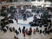  ?? Bob Andres / AJC via AP ?? Security lines wrap through the atrium and around the baggage areas at Hartsfield­Jackson Internatio­nal Airport in the wake of a snowstorm. Hartsfield-Jackson Atlanta Internatio­nal Airport said in a statement that crews were de-icing airplanes as wintry...