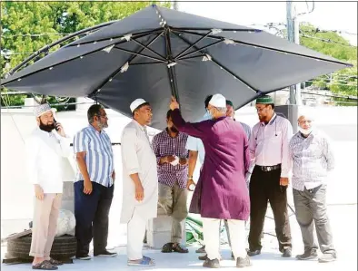  ?? Christian Abraham / Hearst Connecticu­t Media ?? Area Muslims linger in the shade at the Islamic Center of Stamford on Wednesday after services for founder Abdul Rahim, who died this week at age 70 after a two-month battle with liver cancer.