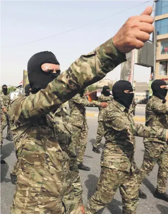 ?? EPA ?? Members of an Iraqi Shiite militia group belonging to the Popular Mobilisati­on Forces on a march in Baghdad. Iran-backed militias are suspected of the attack on Mustafa Al Kadhimi’s home