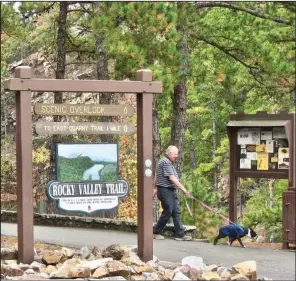  ?? (Special to the Democrat-Gazette/Marcia Schnedler) ?? A hiker walks his dog along one of Pinnacle Mountain State Park’s marked trails.