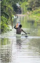  ?? Foto: AFP / Diptendu Dutta ?? Im indischen Westbengal­en müht sich ein Mann durch die Fluten. Neu-Delhi/Dhaka/Kathmandu