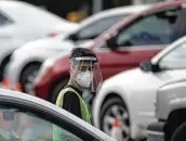  ?? Yi-chin Lee / Staff photograph­er ?? A man directs traffic Wednesday at a COVID-19 test site at Minute Maid Park as positivity rates spike.