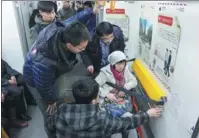 ?? ZHAO JINGDONG / FOR CHINA DAILY ?? Volunteers help a disabled woman use a wheelchair lock on a subway train in Shenyang, Liaoning province.