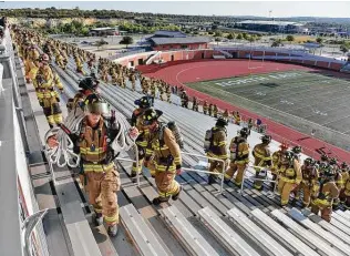  ?? Photos by Robin Jerstad / Contributo­r ?? First responders walk up the steps of Heroes Stadium during the San Antonio 110 9/11 Memorial Climb, honoring those who lost their lives during the terrorist attacks.