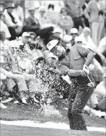  ?? Associated Press ?? LEE ELDER hits a bunker shot at the 1975 Masters, in which he became the f irst Black golfer to play in the tournament. That week, he and his friends were denied service at a local restaurant because of their race.