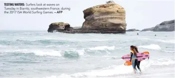  ?? — AFP ?? Surfers look at waves on Tuesday in Biarritz, southweste­rn France, during the 2017 ISA World Surfing Games.