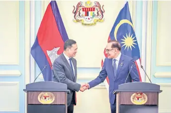  ?? — Bernama photo ?? Anwar (right) shaking hands with his counterpar­t Hun Manet from Cambodian at a joint press conference at the Perdana Putra Building yesterday.