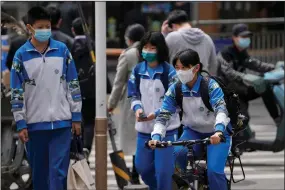  ?? (AP/Andy Wong) ?? Secondary students wander along a street Thursday in Beijing.