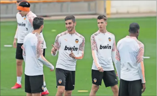  ??  ?? Ferran Torres bromea con Sobrino durante el último entrenamie­nto del Valencia antes de viajar a Milán.