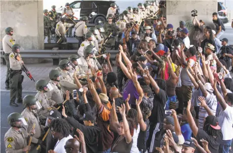  ?? Hayne Palmour IV / Associated Press ?? Police in El Cajon (San Diego County) form a line in front of protesters a day after Alfred Olango was killed by officers in the city.