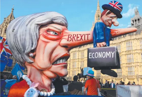  ?? Picture: AFP ?? Anti-Brexit activists demonstrat­e outside the Houses of Parliament yesterday as Prime Minister Theresa May (below) struggled to strike a deal.