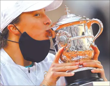  ?? Photo: Nampa/AFP ?? Sweet victory… Poland’s Iga Swiatek celebrates with the Suzanne Lenglen trophy during the podium ceremony after winning the women’s singles final of the Roland Garros French Open against Sofia Kenin of the US on Saturday.