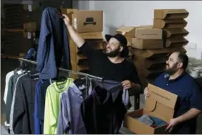  ?? THE ASSOCIATED PRESS ?? In this Aug. 11 photo, co-owners Daniel Franzese, left, and Wil Cuadros select clothes for “The Winston Box” at their showroom in Gardena, Calif. The Winston Box is a monthly subscripti­on box that designs and makes its own clothes for big guys.