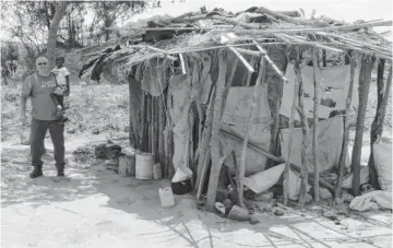  ?? PHOTOS PROVIDED ?? Randy Cloud and Kangwa visit the hut in Zambia where the boy lived after his mother died.