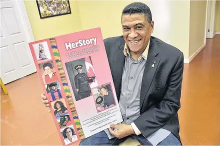  ??  ?? RCMP Sgt. Craig Smith, and author, holds a poster showing the cover of his soon-to-be released new book entitled 'Her Story," which shares the stories of black women who have, and continued, to make a difference in Canadian law enforcemen­t.