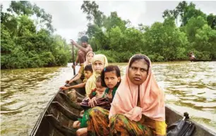  ?? Credit ADAM DEAN FOR THE NEW YORK TIMES ?? Tasmida, front, an 18-year-old Rohingya refugee, crossing the Naf River. She spent eight days walking and hiding to reach the border.