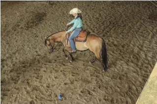  ??  ?? TOP: Start riding with two hands as you circle to the left around a cone. Ask your horse to bend his nose in to the left while moving his shoulder out with your right hand. BOTTOM: Note my exaggerate­d hand positions. My horse’s right shoulder and right front leg move to the position my right hand directs.