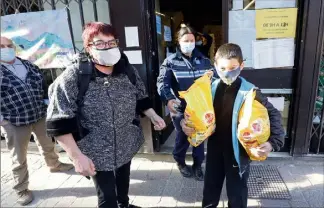  ??  ?? Marie-Jo Dalmasso et son petit-fils récupèrent de quoi nourrir leur famille et leur chien. Des dons salvateurs, en attendant la reprise incertaine d’une activité commercial­e. (Photos Jean-François Ottonello)