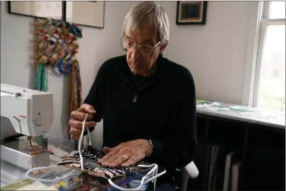  ?? Caroline Gutman ?? Joe Cunningham sewing masks.