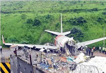  ??  ?? The mangled remains of the Air India Express flight, en route from Dubai, after it skidded off the runway while landing on Friday night, at Karippur in Kozhikode, Saturday.