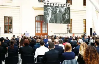  ?? CARSTEN KOALL/DPA VIA AP ?? Guests watch the screening of the trailer of the film documentar­y “Reckonigs” Thursday at the Jewish Museum during at the commemorat­ive event “70 Years of the Luxembourg Agreement” at the Jewish Museum in Berlin, Germany.