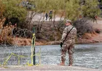  ?? Jerry Lara / Staff photograph­er ?? A Texas National Guardsman stands by a boat ramp on the Rio Grande near the internatio­nal bridge in Eagle Pass this month.