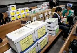  ?? LANNISWATE­RS / THE PALM BEACH POST ?? Boxes of legal documents fifill rows in the courtroomM­onday. The judge said that even at the end of the trial, it’s unlikely he will be able to sort through complex fifinancia­l and legal issues and immediatel­y divide the property.