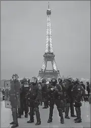  ?? AP/KAMIL ZIHNIOGLU ?? French riot police stand ready Saturday in the Trocadero plaza during a demonstrat­ion in Paris.