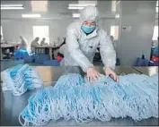  ?? Getty Images ?? A WORKER sorts face masks in Nanjing, China. The country is a leading producer of protective gear.