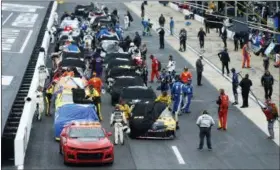  ?? WADE PAYNE — THE ASSOCIATED PRESS ?? Crews cover their cars as a rain delay is called during a NASCAR Cup Series auto race, Sunday in Bristol, Tenn.